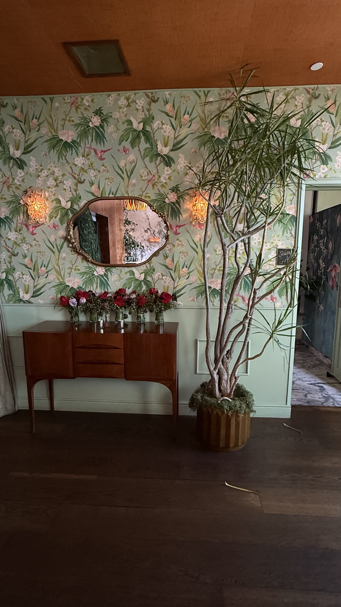 Sculptural branches and roses at the mirrored sideboard